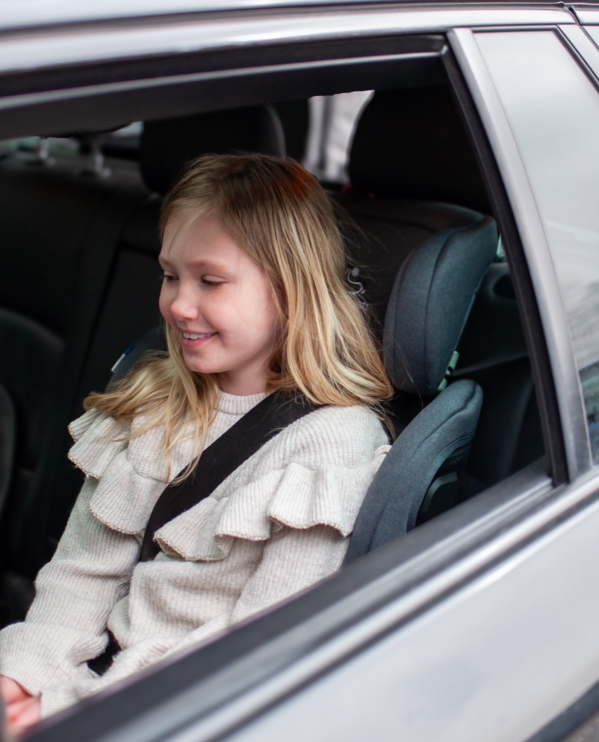 Stor jente fremovervendt i TinySeats Two som beltestol