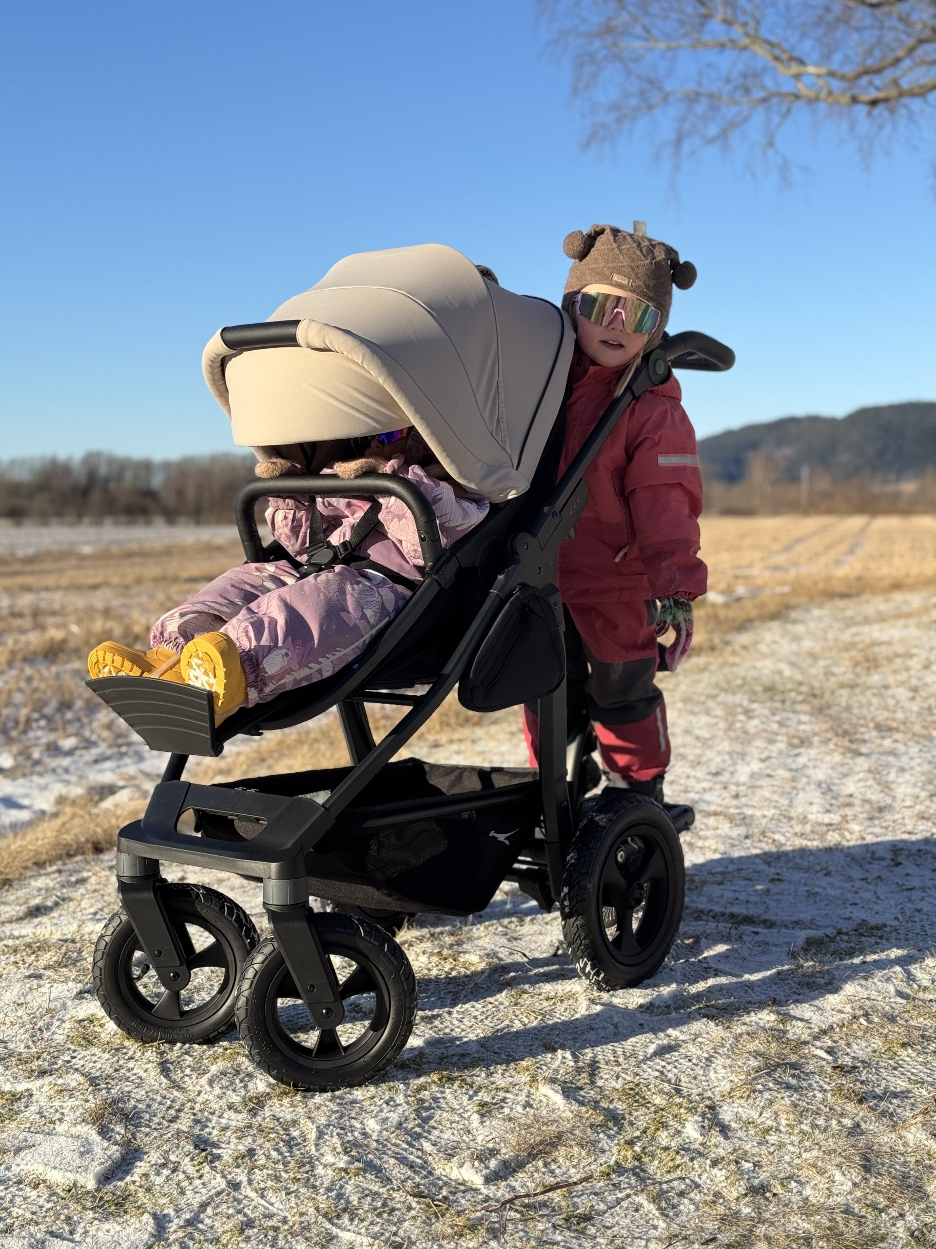 Søsken på TFK Mono 4, med søskenbrett MultiBoard. To og fire år, kombidelen som er babybag først, så sittedel. Kan brukes begge veier.